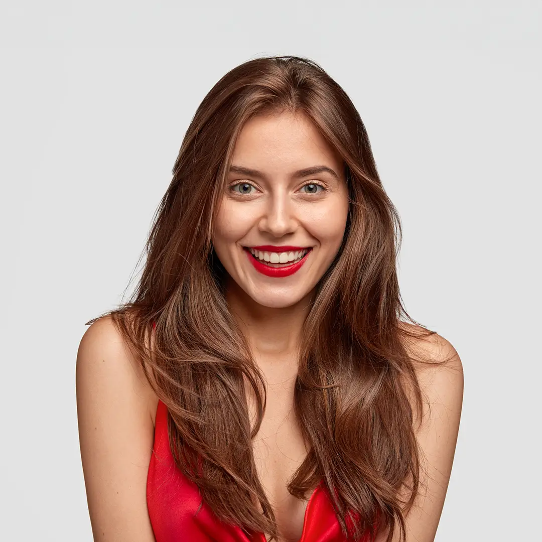 A Brunette Young Woman Wearing Red Lipstick And Smiling With Her Teeth Seen