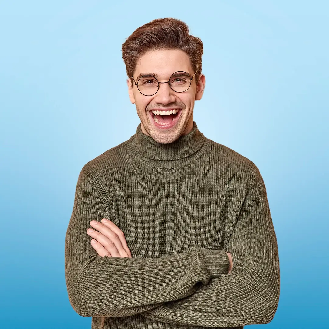 An Image Of A Young Man Wearing Glasses And Smiling With His Arms Folded
